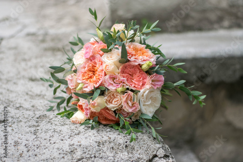 Beautiful bridal bouquet of white flowers and greenery, on a gray textural background. Copy space