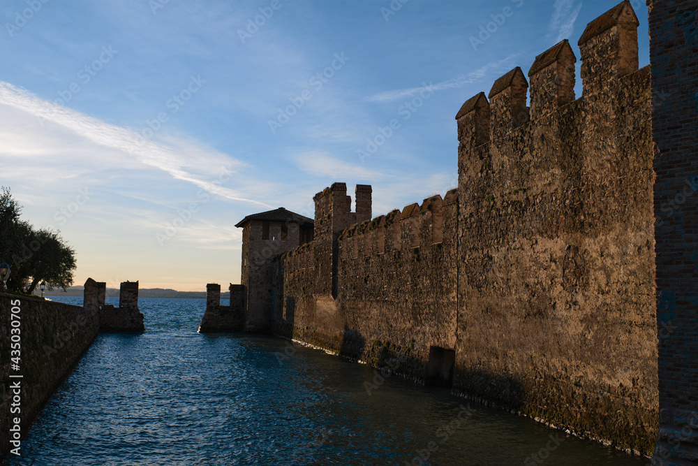 Sirmione Castle, Italy. Close-up of an ancient castle in Italy. Castle tower. Historic castle wall on the water. Fortress on the water.