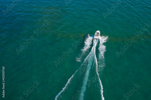 Motor boat in the sea.Travel - image. Aerial bird's eye view photo taken by drone of boat. Top view of a white boat sailing to the blue sea. © Berg