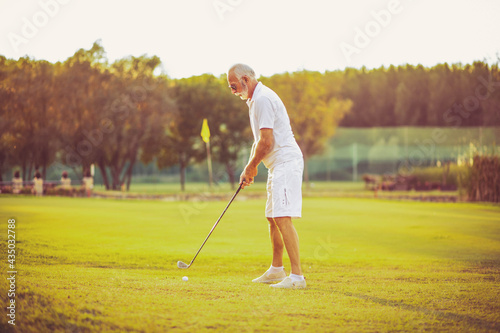 Senior man playing golf alone.