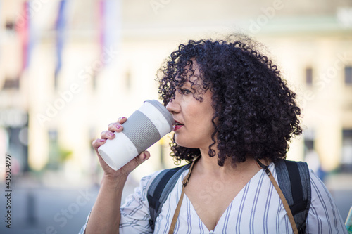 Fotografia Woman on street and drinking coffee. Looking at camera.