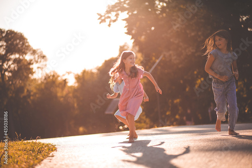 Three smiling little girls running trough nature.