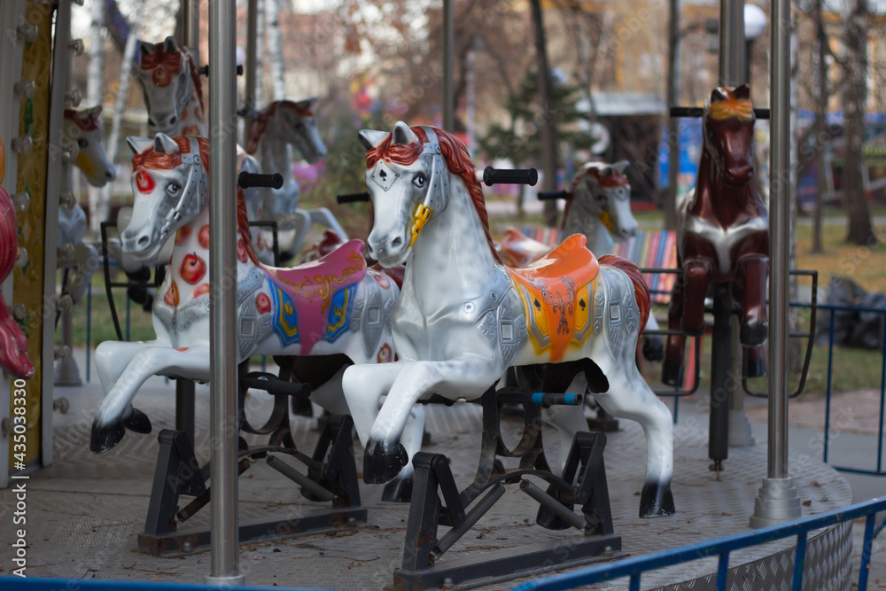 Empty children's entertainment carousel. Running horses carousel. City park. Focus on the Central horse. Empty children's entertainment carousel. Running horses carousel. City park. Focus on the Central horse.