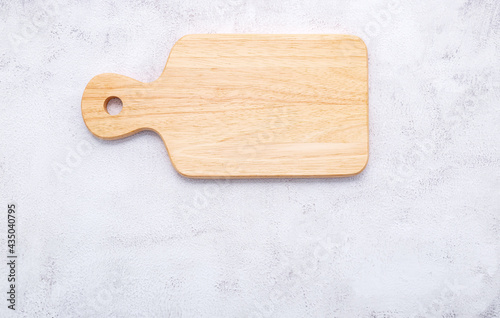 Empty vintage wooden cutting board set up on white concrete background with copy space.