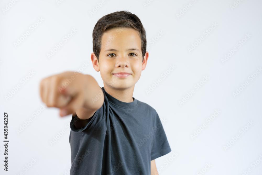 Boy standing and pointing on you over white background Boy standing and pointing on you over white background