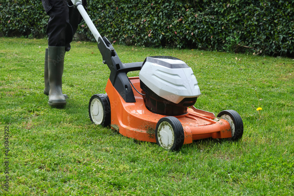 gardener mowing the lawn with a lawn mower gardener mowing the lawn with a lawn mower