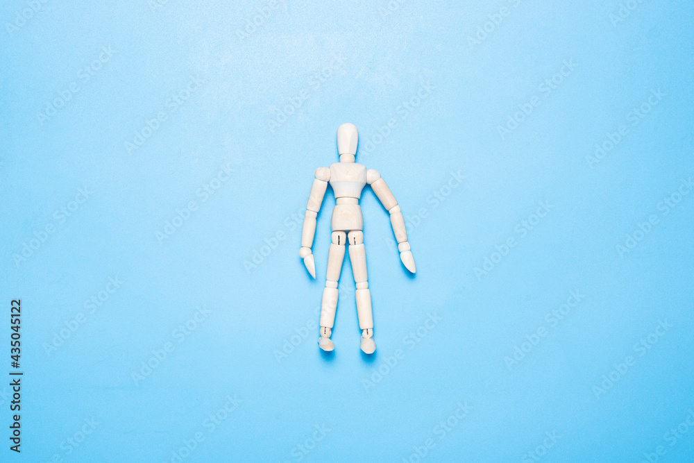 wooden man puppet on a blue background. Top view, flat lay