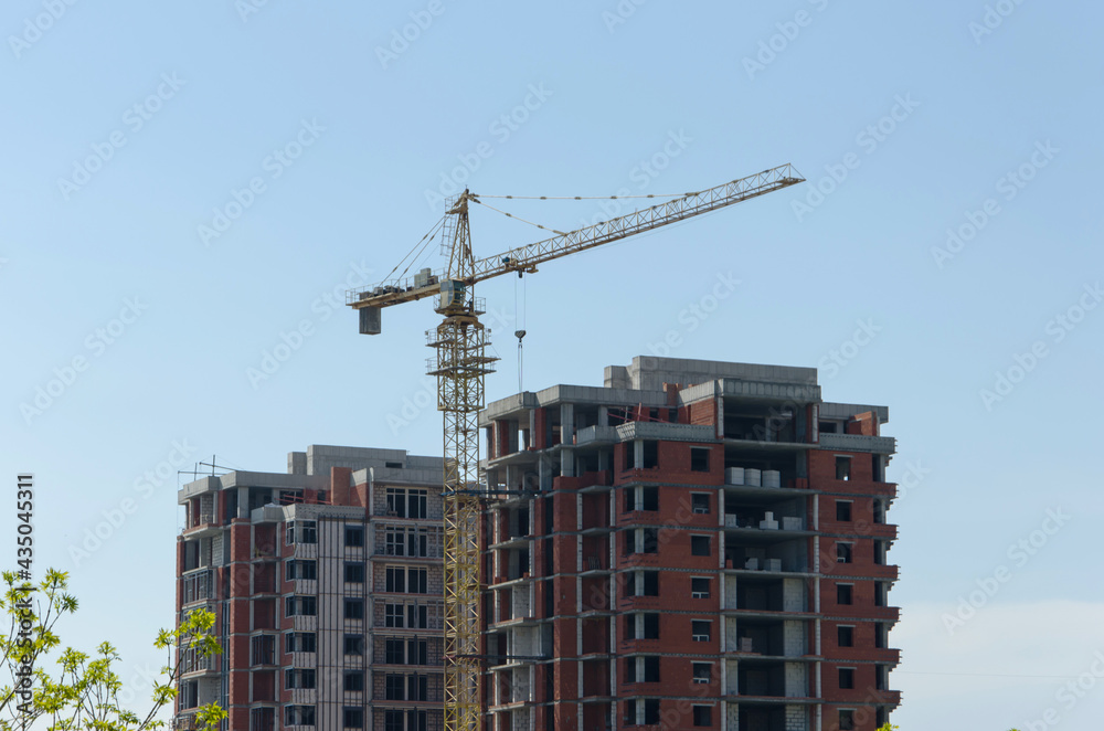 Construction of a multi-storey building. a skyscraper, a construction crane near an unfinished house. Construction of a high-rise in the city. selective focus