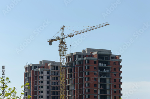 Construction of a multi-storey building. a skyscraper, a construction crane near an unfinished house. Construction of a high-rise in the city. selective focus