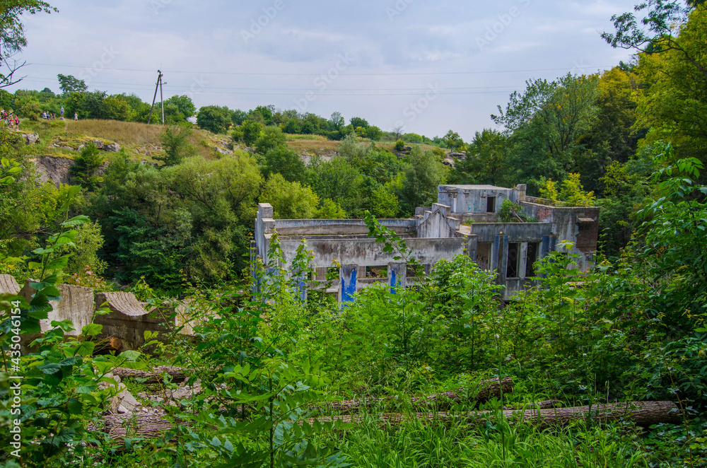 An old building of the power station among green trees, Buky Canyon Ukraine, the Hirskyi Tikych river, the Cherkasy Oblast An old building of the power station among green trees, Buky Canyon Ukraine, the Hirskyi Tikych river, the Cherkasy Oblast