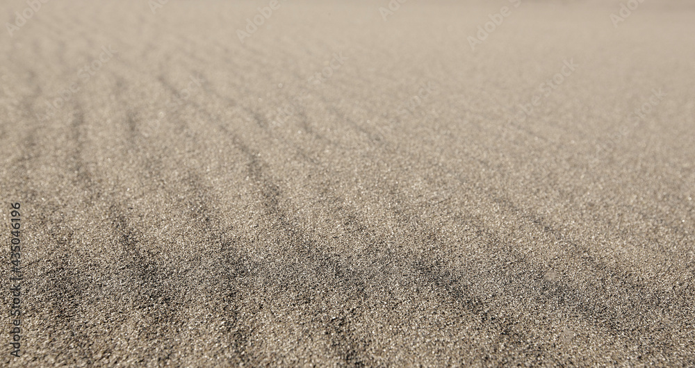 Textured wavy gray sand all over the frame. Selective focus Textured wavy gray sand all over the frame. Selective focus