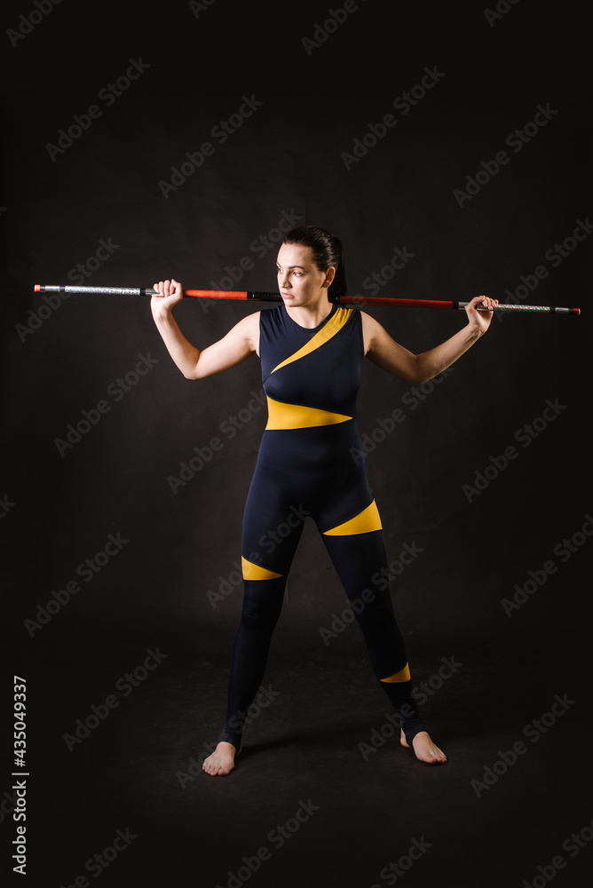 Sports woman with stick doing different stance on black background