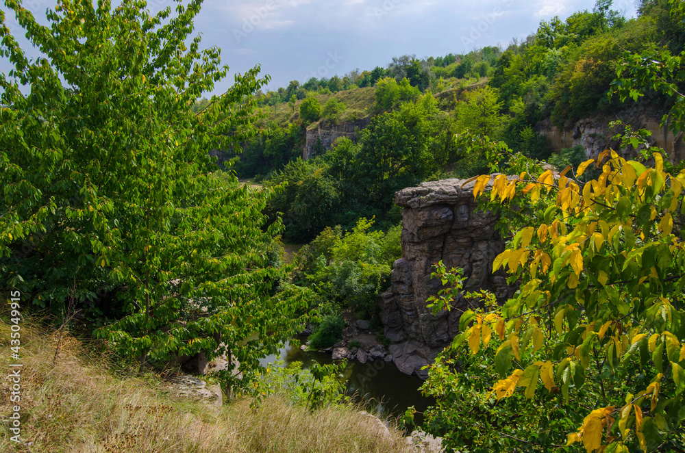 The river flows in a stone canyon among the green trees, Buky Canyon Ukraine, the Hirskyi Tikych river, the Cherkasy Oblast