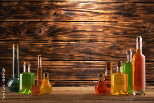 Vintage glass bottles with colorful liquids on the table. Fake remedy, homeopathy, and unscientific medicine concept. photo