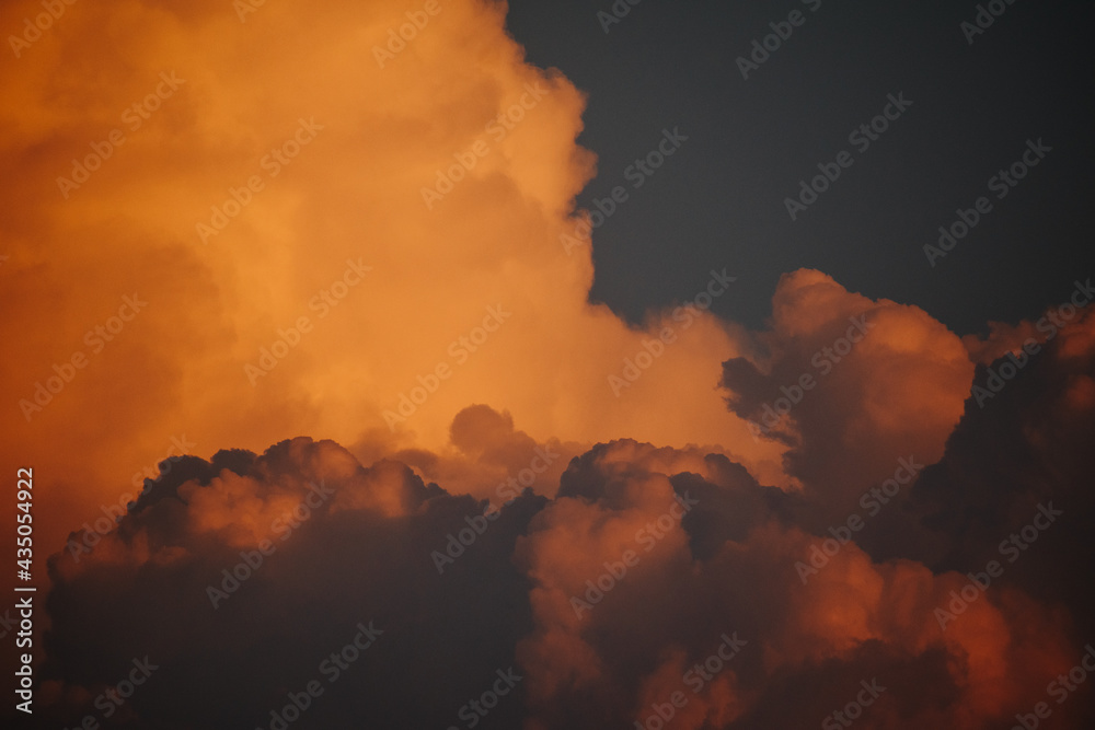 Close up shot of orange colored fluffy sunset clouds in sky