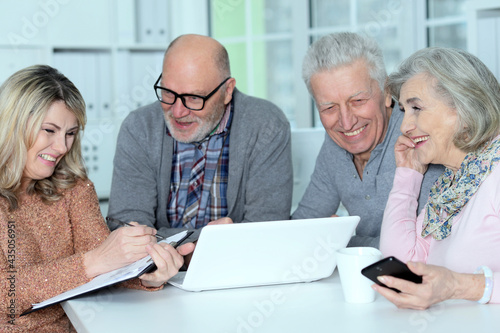 two senior couples sitting at table