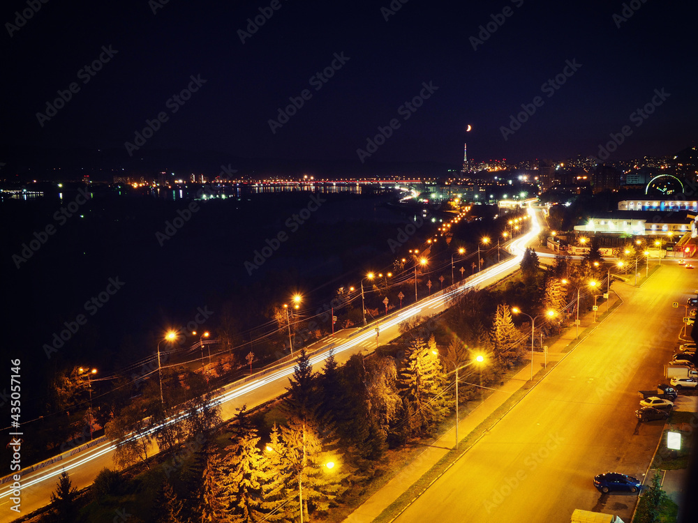 View from the roof of the house to the night embankment of Krasnoyarsk and the city with night lights