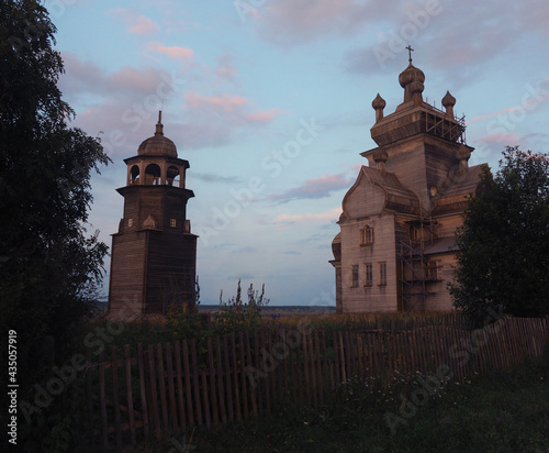 The temple complex of the wooden church of the Turchasovsky churchyard in the village of Turchasovo, Arkhangelsk region in the evening photo