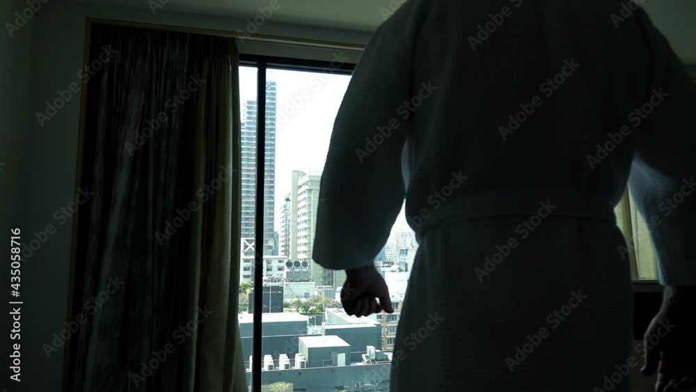 Young man stretching arms by window at home, slow motion Young man stretching arms by window at home, slow motion