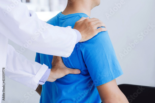 Male doctor therapist working examining treating injured back.Back pain patient  treatment  medical doctor massage for back pain relief office syndrome.