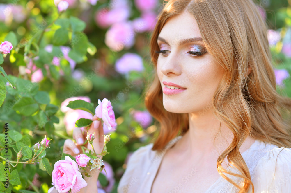 beautiful young woman posing by rose bush beautiful young woman posing by rose bush