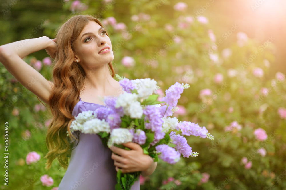 Fototapeta premium portrait of beautiful young woman posing with lilacs