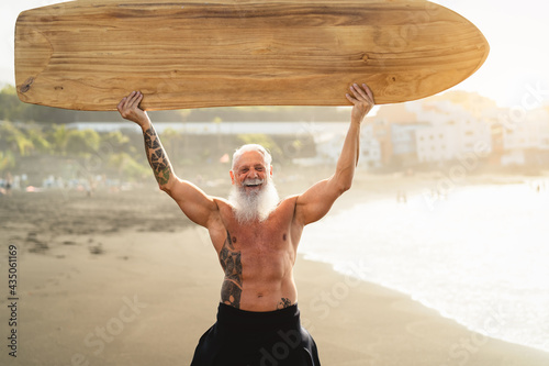 Photography Senior man having fun surfing during sunset time - Fit retired male training wit