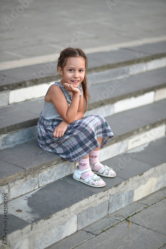 Portrait of smiling little girl sitting on stairs © aletia2011