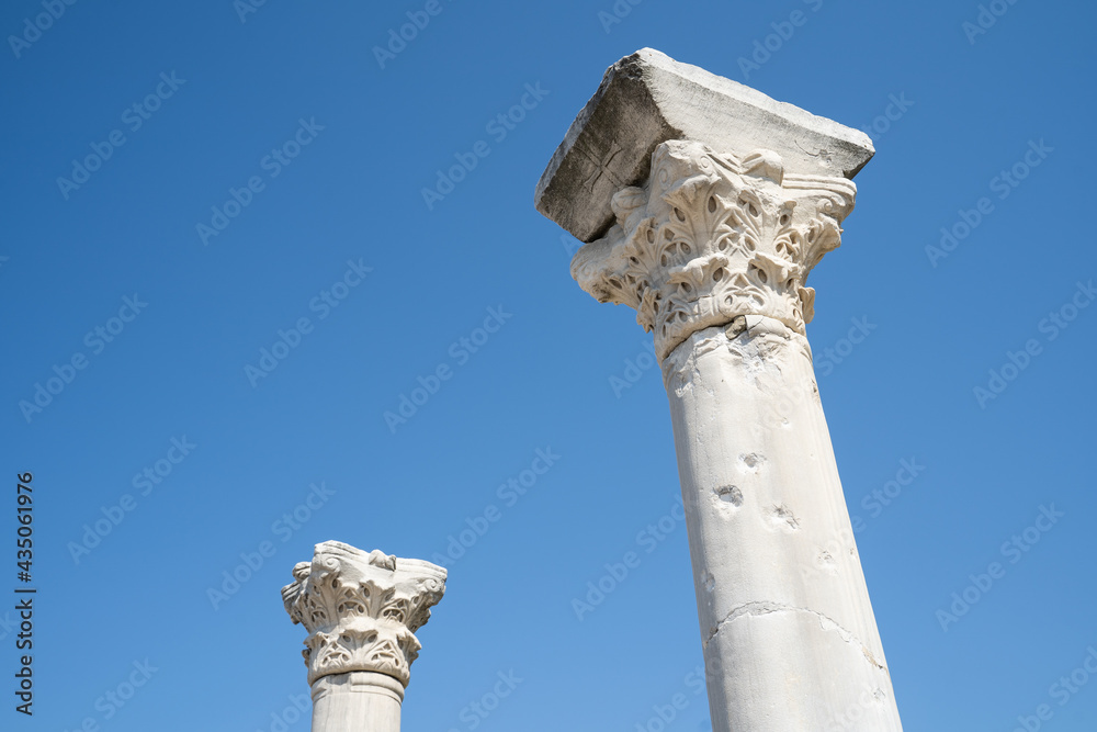Beautiful ancient columns in the rays of the bright sun. Columns against the blue sky. Ancient columns are our history