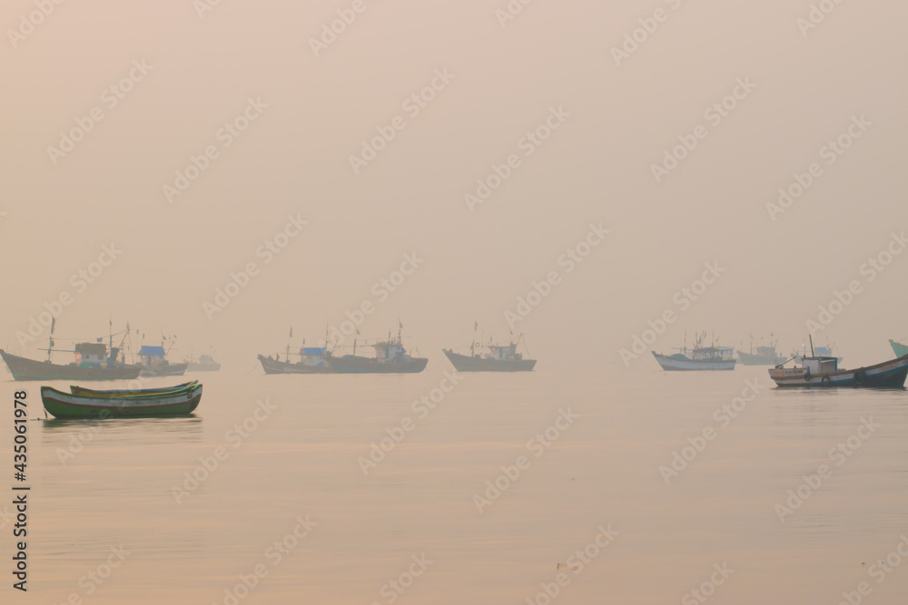 Boats standing in the sea with fog in the background at mumbai madh beach