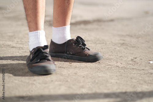 Male student wearing black sneakers Standing in the sun By choosing to shoot only the legs and shoes