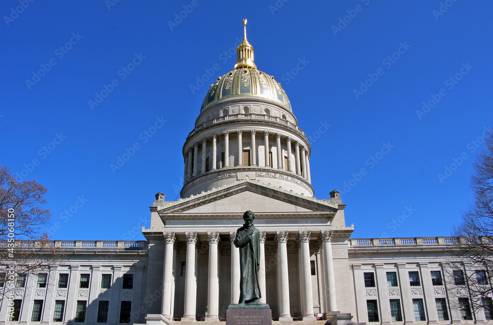 Fototapeta premium The West Virginia Capitol glows in the sun with the Abraham Lincoln statue in the foreground.