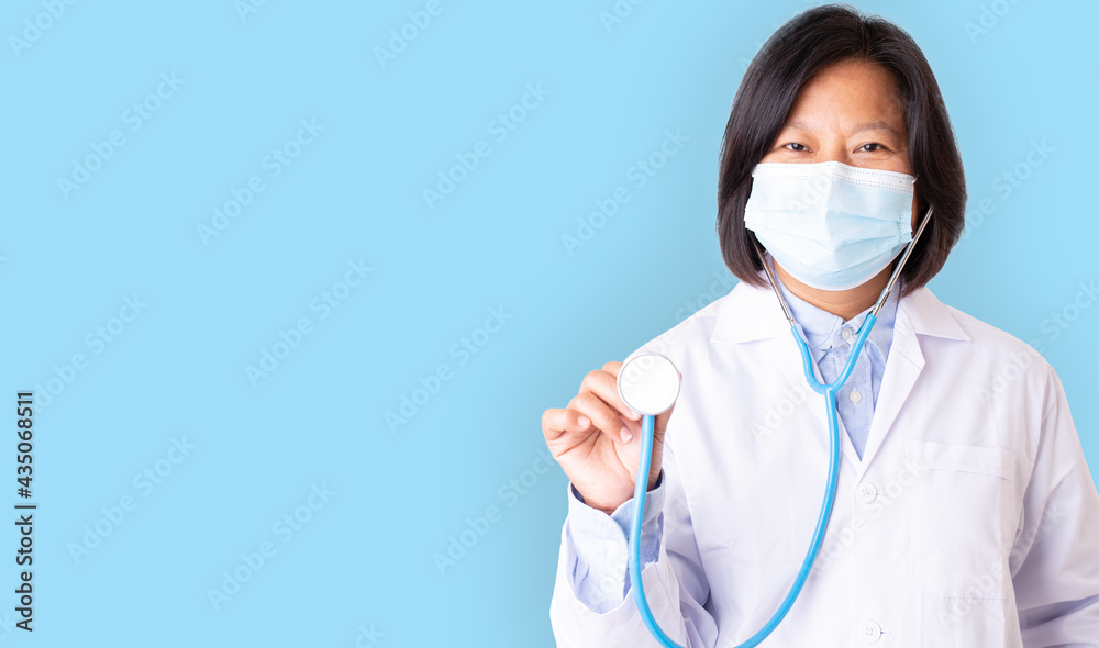 Portriait woman doctor, medical doctor wearing mask white coat, hand holding blue stethoseope, with copy space concept, female doctor in uniform wearing protection mask isolate blue background. Portriait woman doctor, medical doctor wearing mask white coat, hand holding blue stethoseope, with copy space concept, female doctor in uniform wearing protection mask isolate blue background.