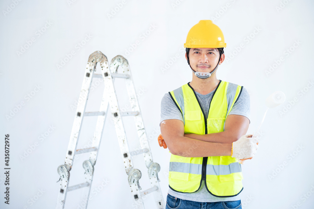 Young worker paints walls in a creative home, house painter. Young worker paints walls in a creative home, house painter.