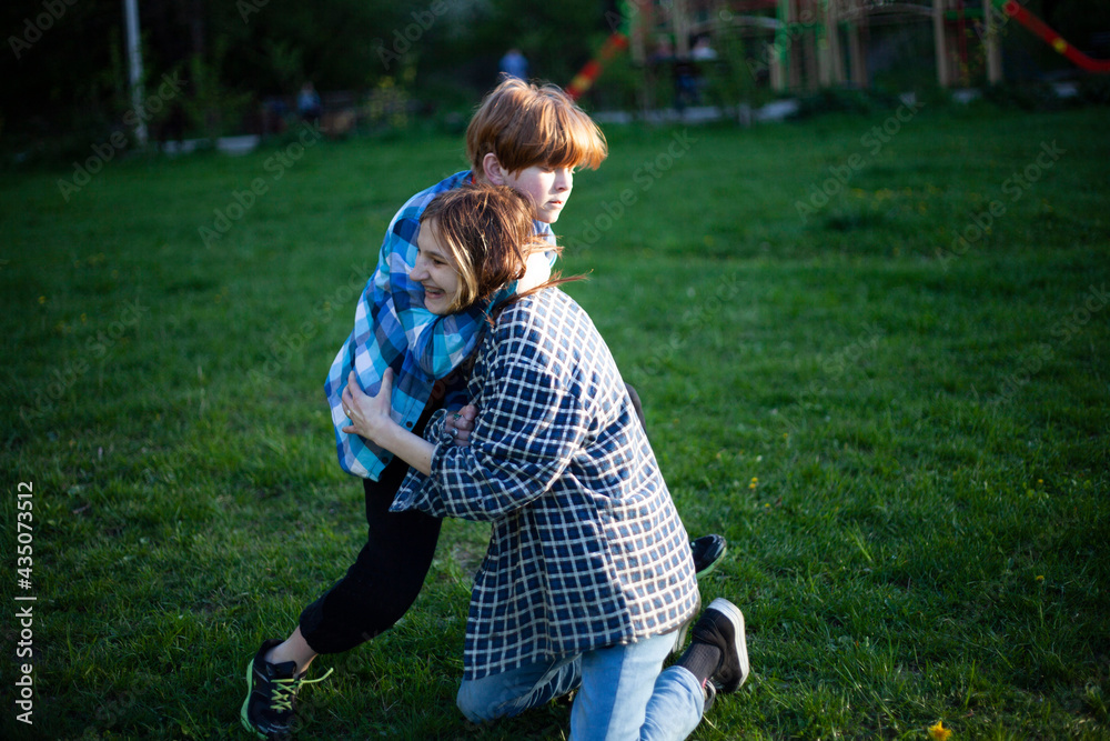 Boy and girl teenagers are fighting on the grass in nature Boy and girl teenagers are fighting on the grass in nature