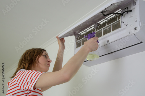 Woman repairing air conditioner at home.