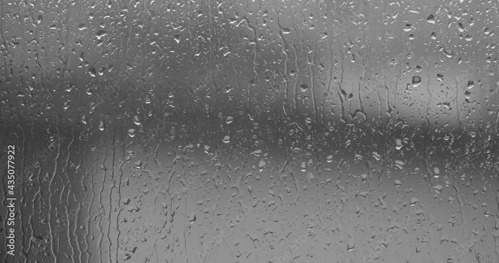 Streams of raindrops on window glass