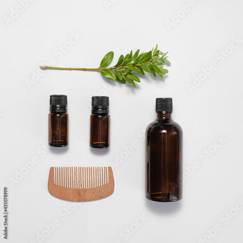 Fototapeta Naklejka Na Ścianę i Meble -  flatley with glass bottles of brown color and a wooden comb on a white isolated background. natural hair care