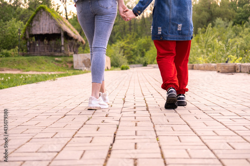 Mother and teenage daughter walking in a park, woman and teenage girl hanging out in a city, lifestyle family