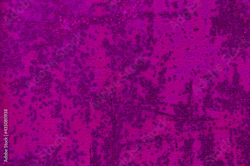 The abstract background is a texture of bright pink and magenta color made of metallic corrosion and rust surfaces. Fashionable rusted iron with spoiled old paint. High quality photo