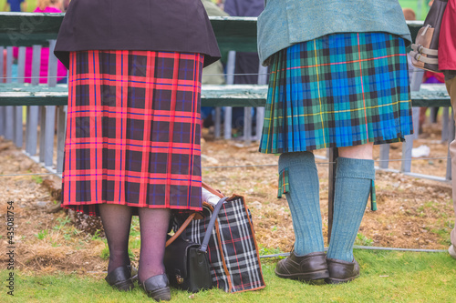 Traditional Scottish tartan pattern on kilts of an elderly couple at ceremonial highland games in Scotland.