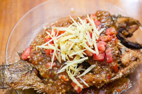 Fried Tilapia with Chili on a Wooden Table, Soft Focus Photo