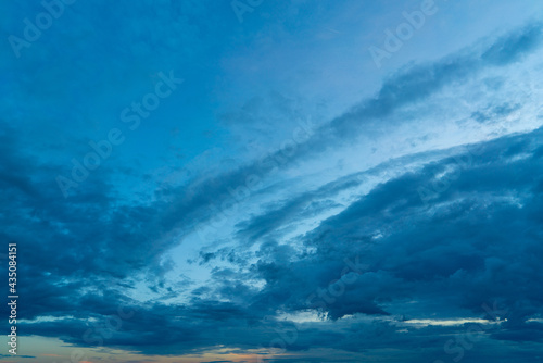 Dark blue clouds in the sunset sky. Natural atmospheric texture.