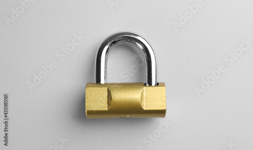 Modern padlock on light background, top view