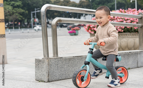 Asian women and their sons ride a balance car in the square