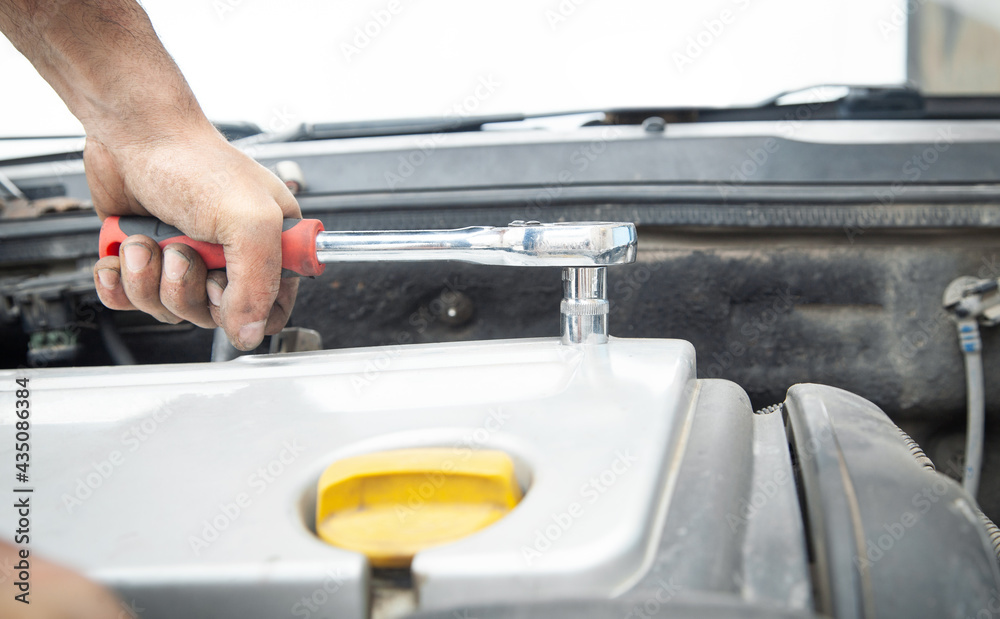 Mechanic repairing car with ratchet wrench. Mechanic repairing car with ratchet wrench.