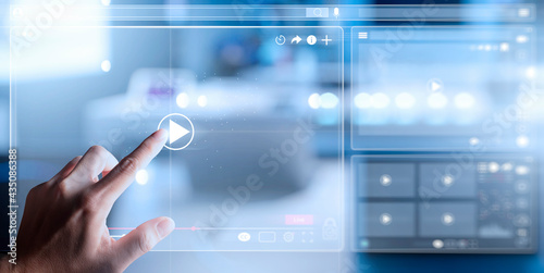 Video streaming on internet Concept.Businessman watching online movie or TV series on modern computer virtual screen with multimedia player with play button icon.