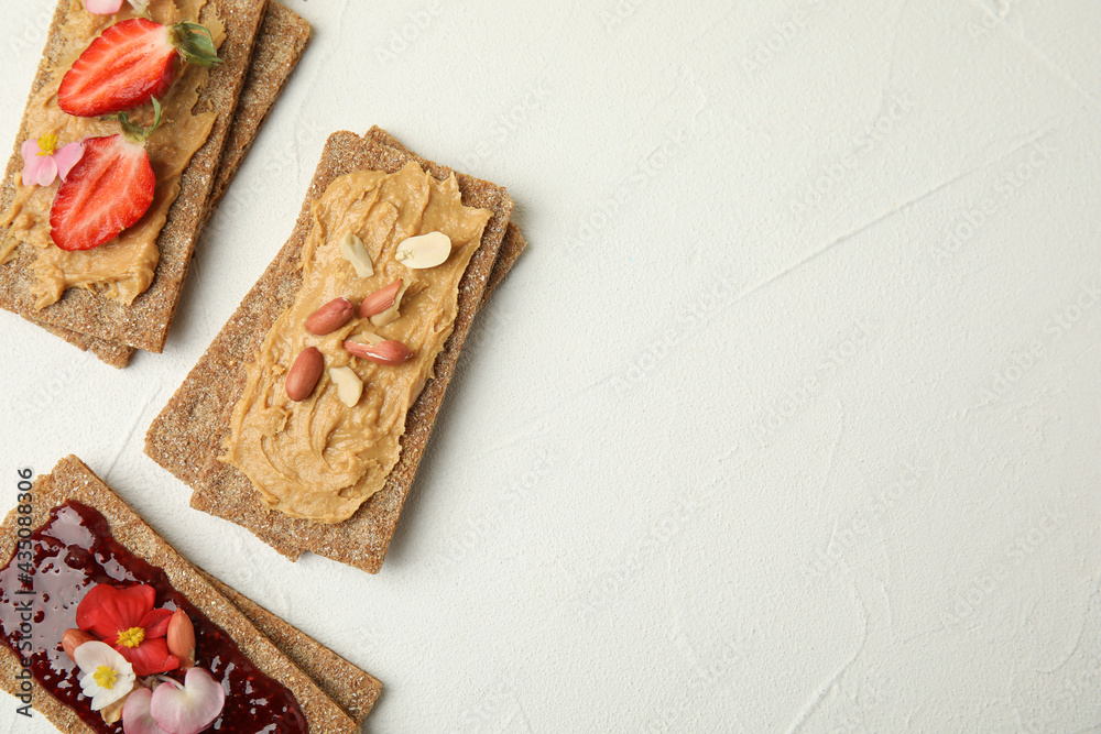 Fresh rye crispbreads with different toppings on white table, flat lay. Space for text Fresh rye crispbreads with different toppings on white table, flat lay. Space for text