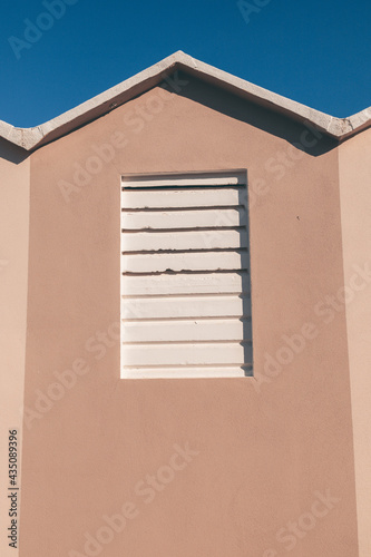 Close up shot of the typical beach huts and cabins in a beach in the Riviera Romagnola area of italy. Warm pastel colors in cotrast with a blue sky. Vintage summer mood and atmosphere. photo