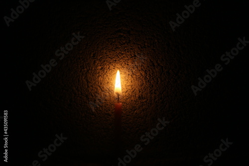 burning candle on black background